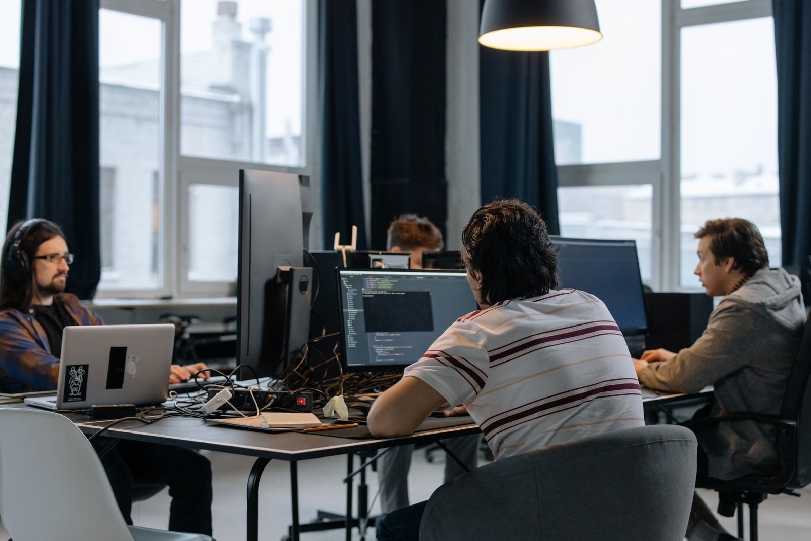 A team of developers collaborating around a table with laptops and notes